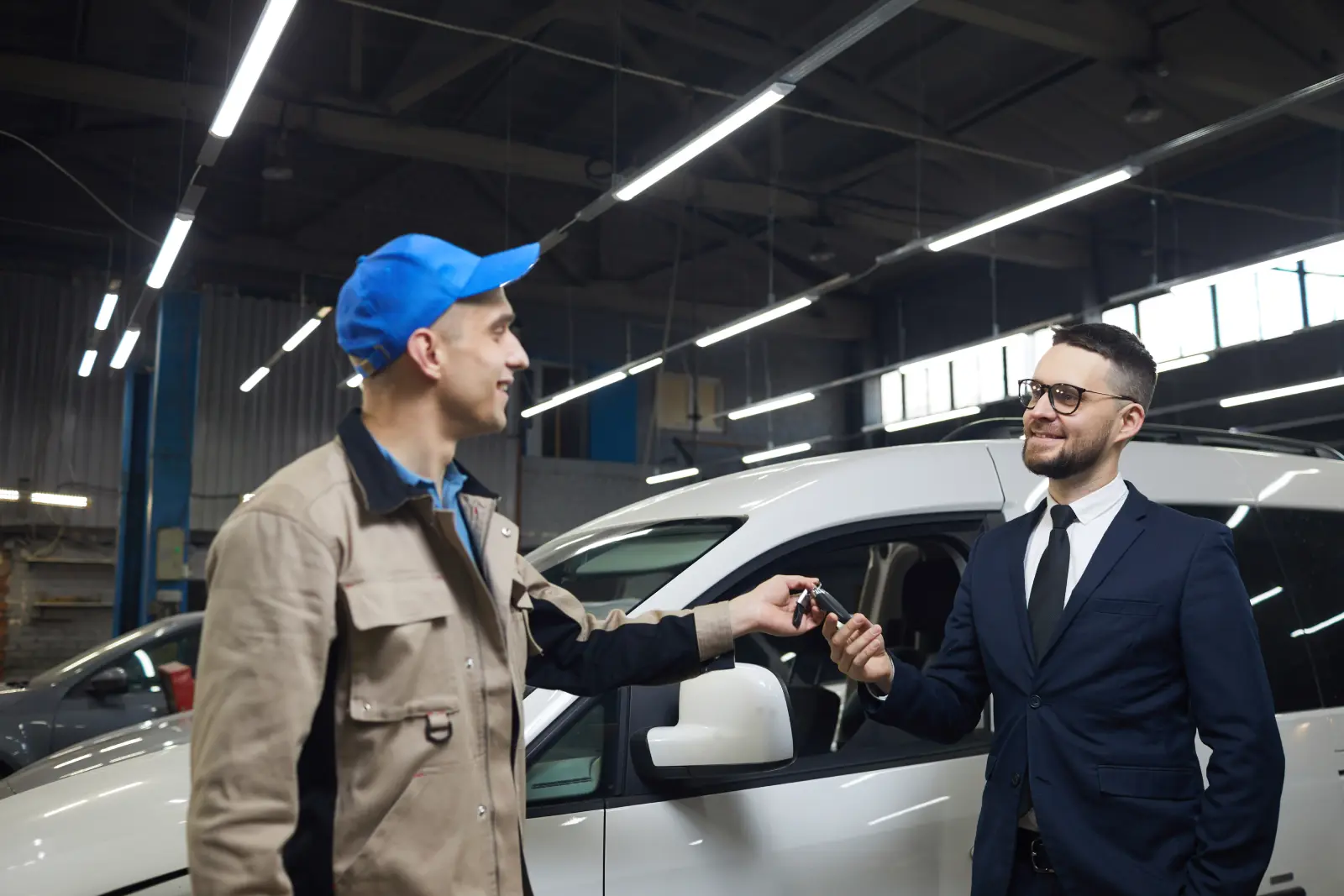 Car mechanic handing keys back to a happy customer